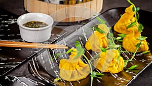 Pan-Asian cuisine concept. Wontons of yellow dough, minced meat. Japanese dumplings with minced meat. Serving dishes