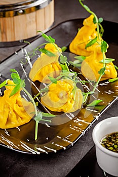 Pan-Asian cuisine concept. Wontons of yellow dough, minced meat. Japanese dumplings with minced meat. Serving dishes