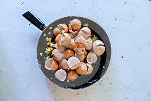 Pan with broken egg shells after cooking scrambled eggs with man