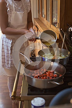 Pan with caramelised tomatoes cherry process of cooking and adding ingredients hands