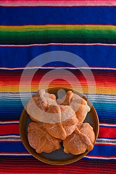 Pan de muerto on colorful serape.