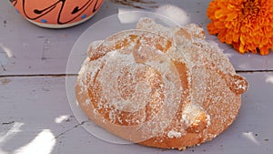 Pan de muerto near coffee cup and cempasuchil flower