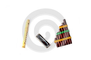 Pan flute, mouth organ and blockflute isolated on white background flat lay