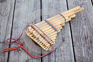 Pan flute or panpipes or syrinx a musical instrument lying on square-edged flooring