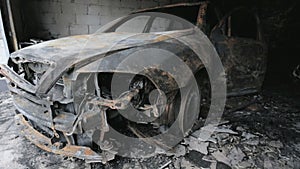 Pan footage of burned out car in garage