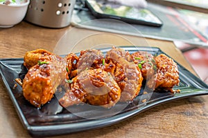 Pan fried chicken Momo served in a black plate over moody background. Selective focus