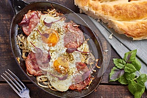 Pan of fried eggs with onion, ham and chard