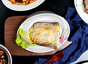 Pan fried fish maw with lemon, spoon and fork served in dish isolated on wooden board top view of taiwan food photo