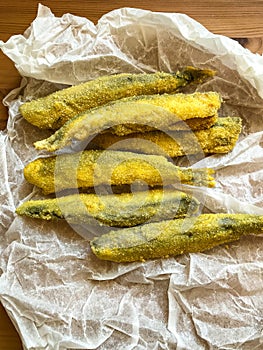 Pan fried fish on a plate. Capelin fried in oil with crispy breading.