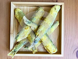 Pan fried fish on a plate. Capelin fried in oil with crispy breading.