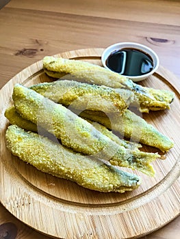 Pan fried fish on a plate. Capelin fried in oil with crispy breading.