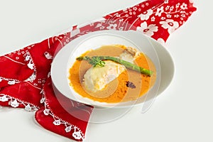 Pan-fried Salmon fish with gravy in a dish isolated on colorful table cloth top view on grey background