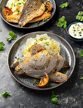 Pan fried sea bass fillets served with mashed potatoes and caramelised lemon