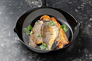 Pan fried sea bass fillets served with mashed potatoes and caramelised lemon