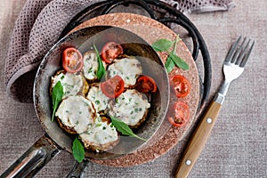 Pan-fried zucchini with garlic sauce and cherry tomatoes. Next to arugula, napkins, fork and mayonnaise.