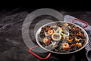 Pan full of arroz negro on napkin photo