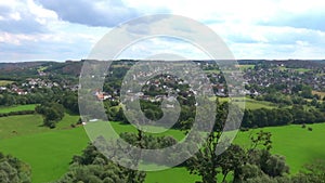 Pan over a village near Dortmund, Germany, with green meadows and single family houses, aerial view