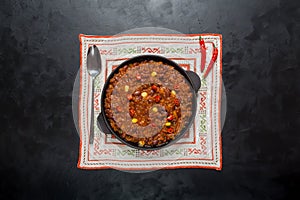 Pan of Texas chili on black background.