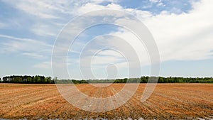 Pan of tractor cultivating farmland in rural Georgia fresh soil