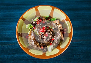 Pan of traditional Japanese yakitori dish - fried checken hearts served with sesame, teriyaki sauce and fresh vegetables at wooden