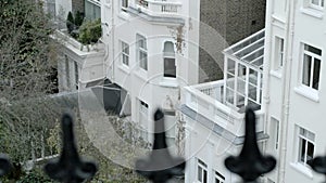 Pan up, pull focus from old victorian iron railings to a London home.