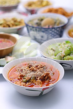 Panaeng Curry with Pork.Sliced M in red curry paste and coconut milk in a bowl on the set of group plates Thai food. Top view.