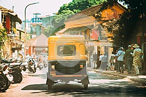 Panaji, Goa, India. Yellow Auto Rickshaw Or Tuk-tuk Moving On Street In Sunny Day