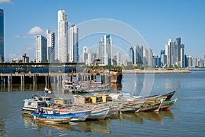 Fishing boats at commercial fish market harbour with skyline bac