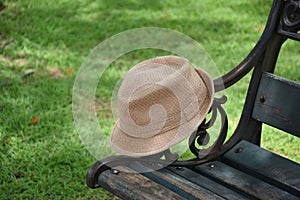 Panama hat on wooden chair with green grass field background