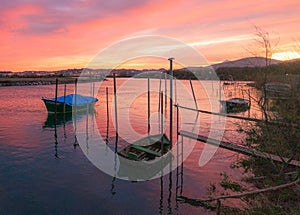 Panaromic shot of a beautiful colorful sunset on the seashore with fishing boats