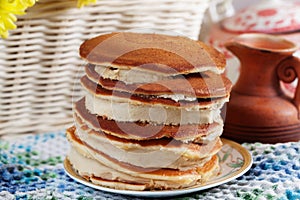 Pancake cake with cream on a plate Still