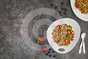 Pancake cereal. Trendy food, mini cereal pancakes in bowl on the table, grey cement background. Trendy baked mini