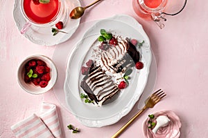 Pancake chocolate cake with fresh raspberries on a pink background.