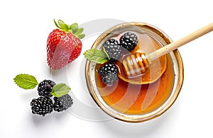 Pancake on a plate with honey, blackberries, and strawberry isolated on white background