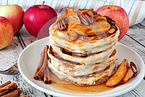 Pancake stack with apples, pecans and cinnamon and maple syrup