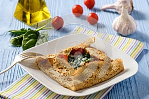 Pancake stuffed with spinach, feta cheese and tomatoes.