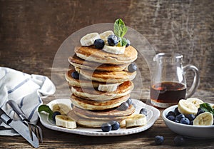 Pancakes with banana, blueberry and maple syrup.