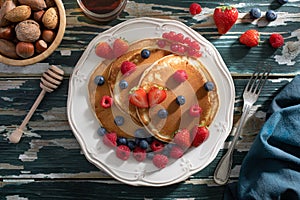 Pancakes with berries on green table