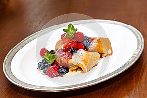 Pancakes with berries on a plate on a table in a restaurant
