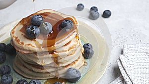 Pancakes with blueberries and maple syrup.