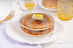 Pancakes with butter and honey or maple syrup drizzles