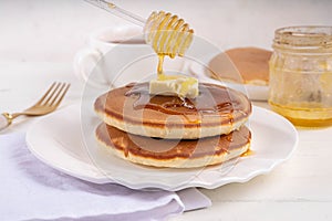 Pancakes with butter and honey or maple syrup drizzles