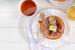 Pancakes with butter and honey or maple syrup drizzles