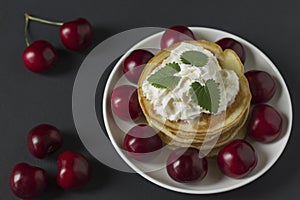 Pancakes with cherries and whipped cream