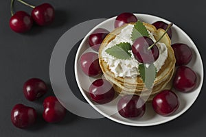 Pancakes with cherries and whipped cream