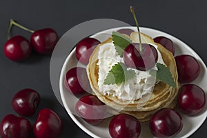 Pancakes with cherries and whipped cream