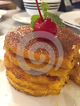 Pancakes with a cherry topping and mint leaf garnish