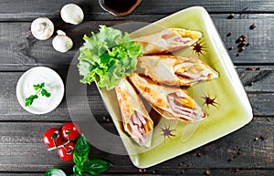 Pancakes with chopped ham and cheese, decorated with lettuce on dark wooden background close up.