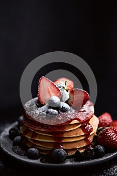 Pancakes close up, with fresh strawberry, blueberries, mint and jam