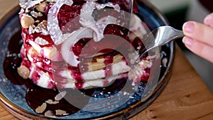 Pancakes with coconut flakes, red cherry jam and berries. Pancakes with berry syrup